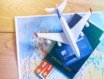 Air tickets, passports and credit card on world map. Online ticket booking and holiday planning concept