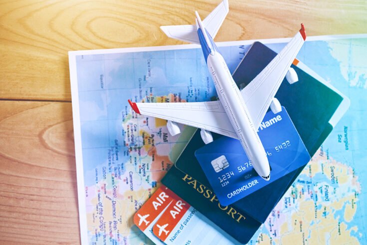 Air tickets, passports and credit card on world map. Online ticket booking and holiday planning concept