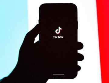 Une main tenant un cellulaire logo de TikTok